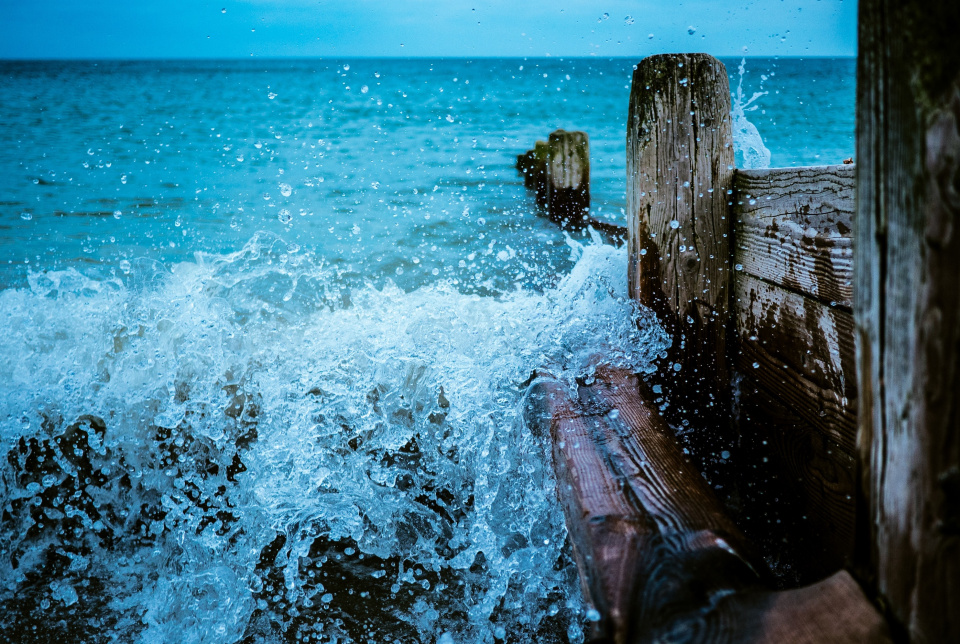 Waves crashing into an old pier