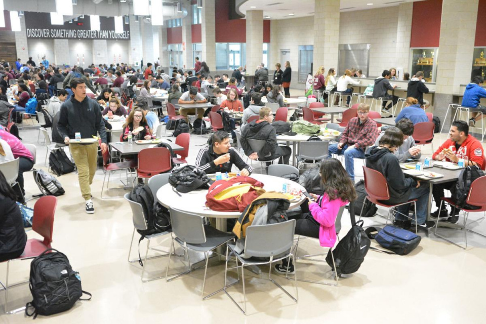 groups of students eating in a lunch room