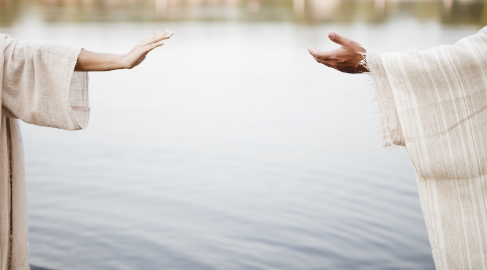 Two people reaching for each other's hands