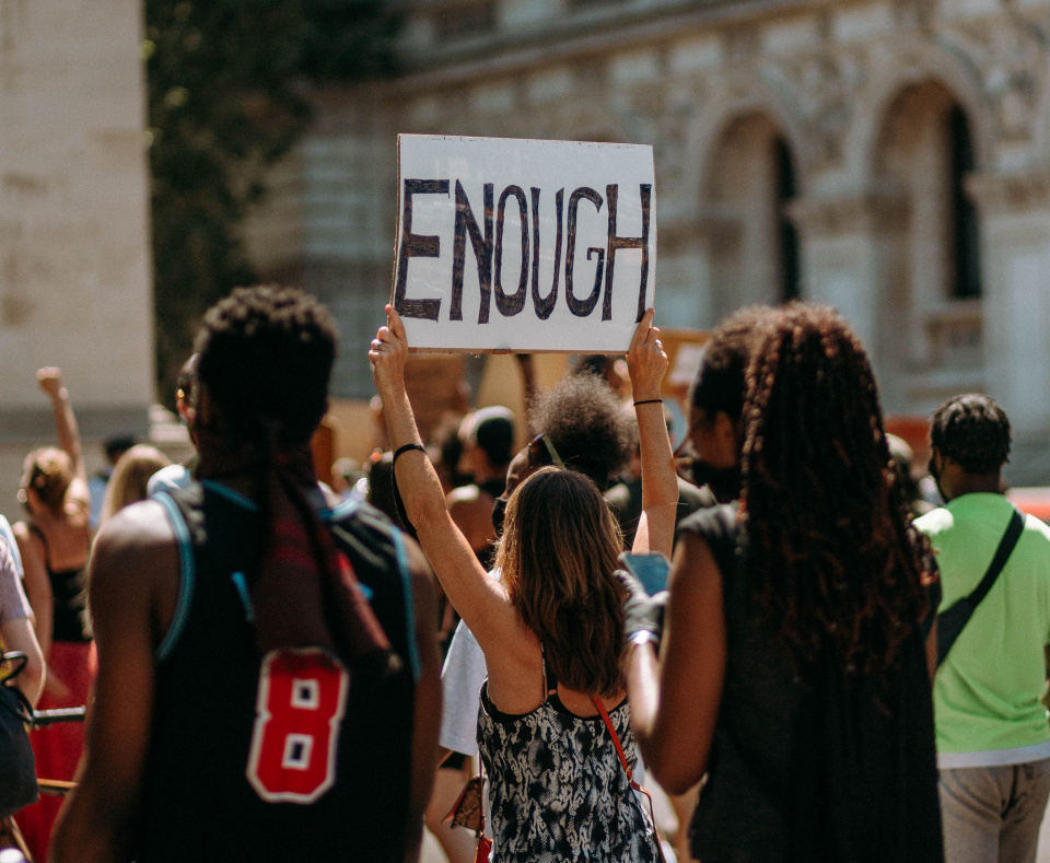 protestor holding sign that says "enough"