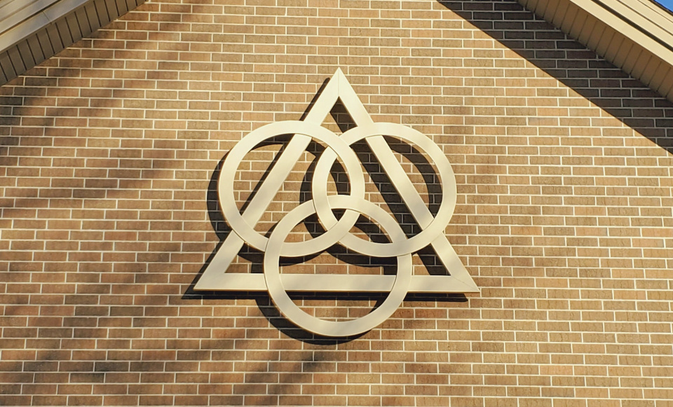 symbol depicting the Holy Trinity on the side of a brick wall of a church