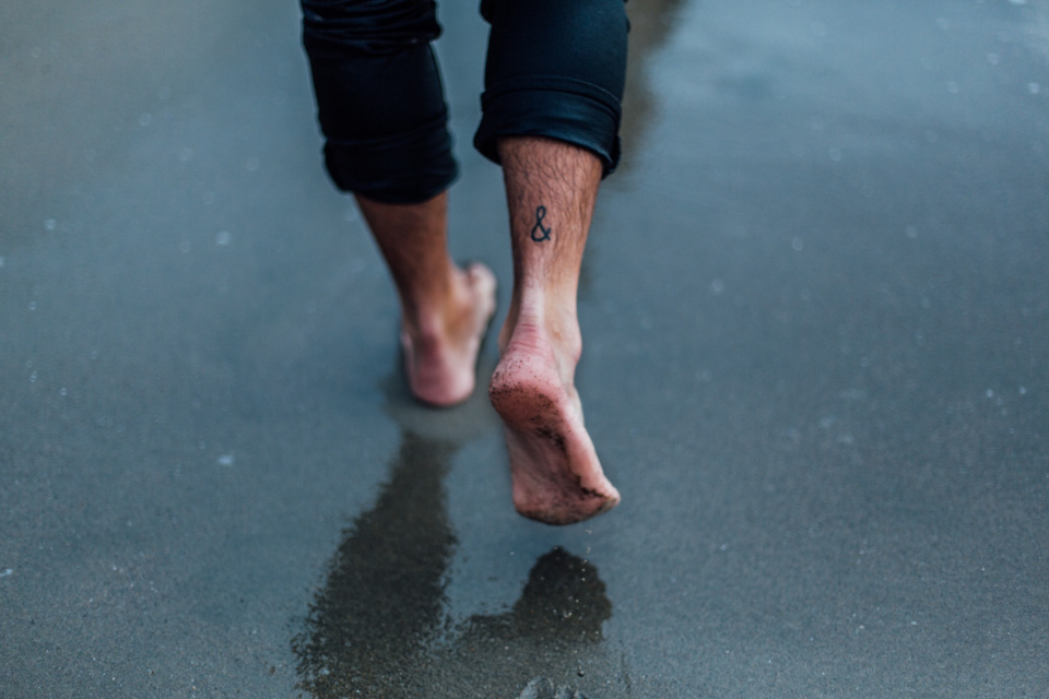 person walking in wet sand