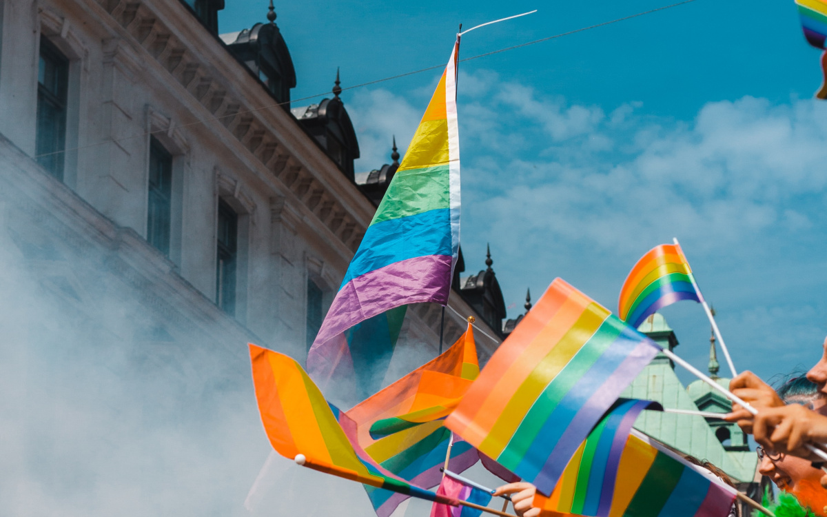 Rainbow flags waving in the air during a Pride parade